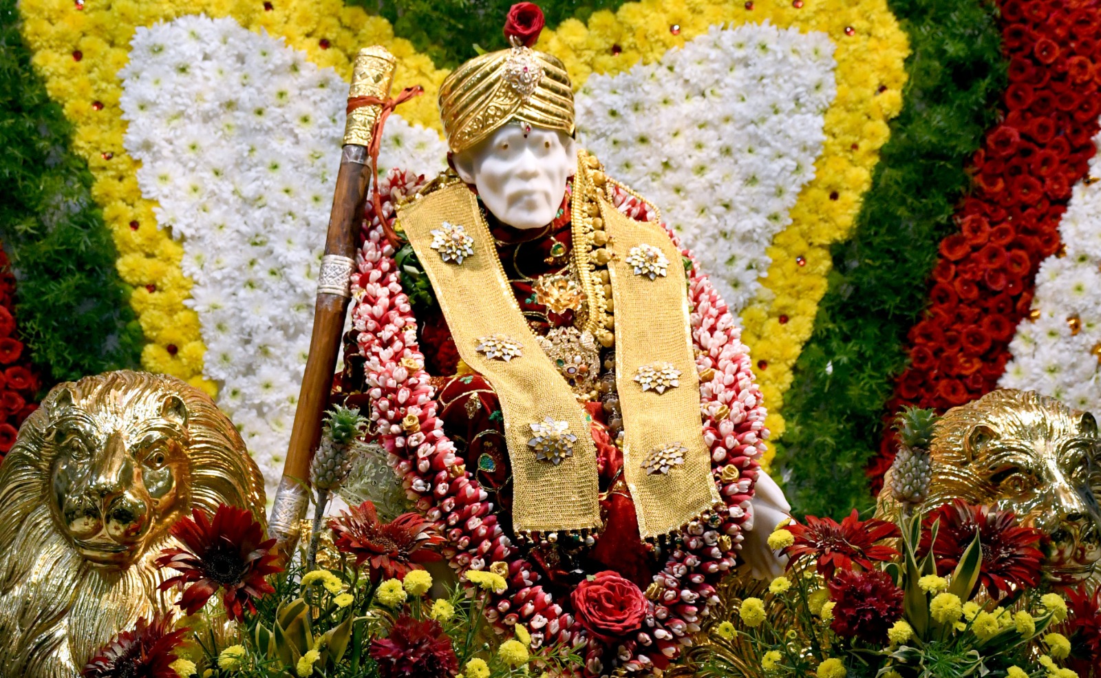 மலர்கள் மற்றும் தங்கக் காசுகளால் அலங்கரிக்கப்பட்டிருந்த சாயிபாபா